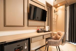 a hotel room with a television and a chair at Casa De Zea by AKA in Yogyakarta