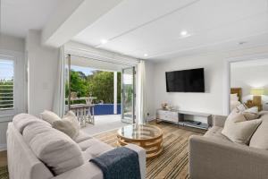 a living room with two couches and a tv at Blue View Gerringong in Gerringong