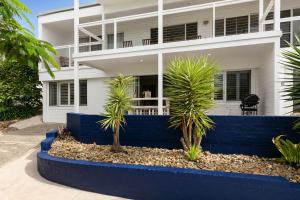 a house with palm trees in front of it at Blue View Gerringong in Gerringong