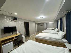 a hotel room with two beds and a television at Ruka Hotel Tennoji in Osaka