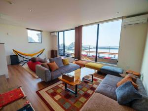a living room with couches and a view of the ocean at Private Ocean Resort YUUNAGI in Awaji