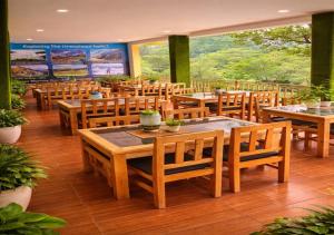 a restaurant with wooden tables and wooden chairs at Hotel MountMemory , Barkot-Yamunotri in Barkot