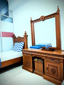 a bedroom with a bed and a mirror on a dresser at Mama Nusantara Hotel in Jertih