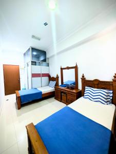 a bedroom with two beds and a mirror at Mama Nusantara Hotel in Jertih