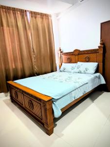 a bedroom with a bed with a wooden frame at Mama Nusantara Hotel in Jertih