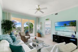 a living room with a couch and a flat screen tv at Spacious Condo - 2 King Suites - Close to Beaches in Marco Island