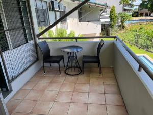 a balcony with two chairs and a table on it at Yatulau Hotel and Conference in Suva