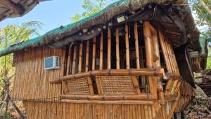 a wooden house with a thatched roof at Rendan Kubo in Batangas City