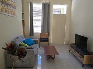 a living room with a couch and a tv at Laguna Ijen Homestay in Banyuwangi
