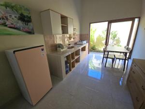 a kitchen with a refrigerator and a table and a window at Laguna Ijen Homestay in Banyuwangi