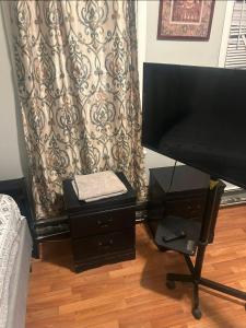 a bedroom with a desk with a television and a curtain at Grove 4- Queen bed with Private bathroom in Irvington +2 photos
