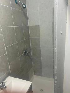 a bathroom with a shower with a toilet and a sink at Grove 4- Queen bed with Private bathroom in Irvington