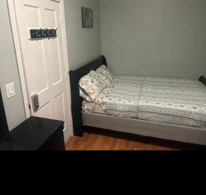 a bedroom with a bed next to a door at Grove 4- Queen bed with Private bathroom in Irvington