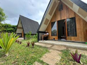 a man sitting on the porch of a house at Zalfa Homestay in Taliwang +17 photos