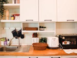 a kitchen counter with white cabinets and a sink at Khunnapat Pool Villa Khaoyai in Mu Si