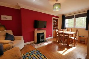 a living room with a red wall at Seal Cottage in Eyemouth