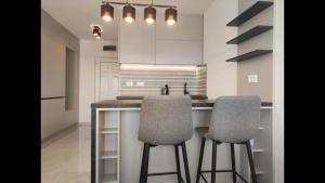 a kitchen with a counter and two chairs at a bar at Apartman Triton in Ulcinj