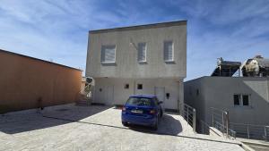 a blue car parked in front of a building at Apartman Triton in Ulcinj +6 photos