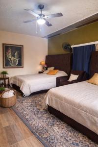 a bedroom with two beds and a ceiling fan at La Casita Inn Bustamante in Bustamante +275 photos