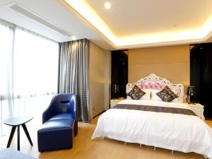 a bedroom with a white bed and a blue chair at Pengman Beijing Road A-mall Apartment - Free Shuttle to Canton Fair in Guangzhou