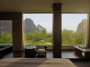 ein Schlafzimmer mit einem großen Fenster mit Blick auf die Berge in der Unterkunft YINGMAN HOTEL in Yangshuo + 109 Fotos