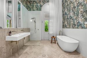 a white bathroom with a tub and a sink at Glenrock Homestead in Bulga