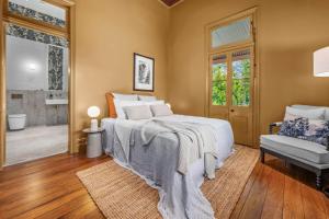 a bedroom with a large bed and a chair at Glenrock Homestead in Bulga