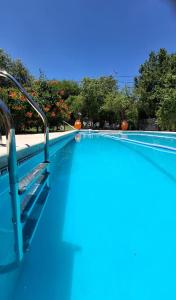 a swimming pool with blue water and metal rails at Cabañas Thijada in Mina Clavero +5 photos