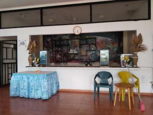 ein Zimmer mit Stühlen und einem Tisch und einer Uhr in der Unterkunft Mesirom B&B in Dili