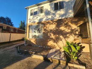 a brick house with a shadow on the side of it at Saltwater Daze - Hosted in Sunshine Bay