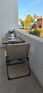 a chair sitting at a table on a balcony at Apartamentos playa Romanilla in Roquetas de Mar