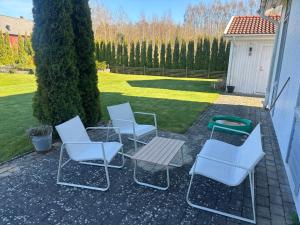 a group of chairs and a table on a patio at Ausås Ängelholm in Ängelholm