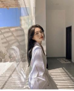 a woman is standing next to a window at 3B MAISON Homestay & Villa in Mui Ne