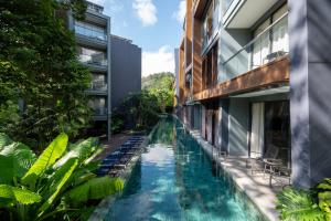 an external view of a swimming pool between two buildings at The Nature Phuket in Patong Beach