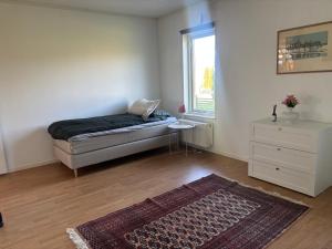 a bedroom with a bed and a window and a rug at Ausås Ängelholm in Ängelholm