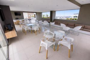 a restaurant with tables and white chairs and a couch at Miraflores Nest Upper Pardo in Lima