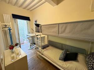 a bedroom with bunk beds in a room with a desk at Charming Mansion in Lucca in Lucca