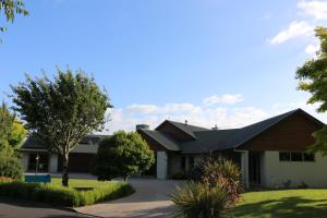 a house with a gambrel roof and a driveway at 200 on Lake View in Karapiro