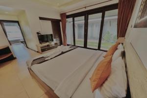 a bedroom with a bed and a large window at The Shore Samui in Bangrak Beach