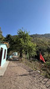 a dirt road next to a building with a tree at Luvyash Campsite Stays in Bhīm Tāl +4 photos