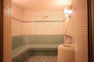 Kanazawa Manten Hotel Ekimae في كانازاوا: حمام مع دش وحوض استحمام ومرحاض