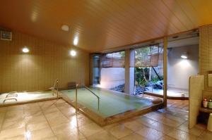 a room with a swimming pool in a house at Kanazawa Manten Hotel Ekimae in Kanazawa