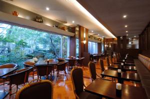 a restaurant with tables and chairs and a large window at Kanazawa Manten Hotel Ekimae in Kanazawa