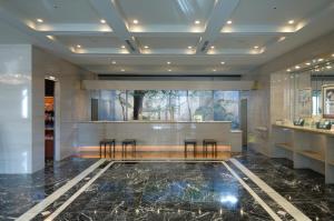 a lobby with a bar with stools in it at Kanazawa Manten Hotel Ekimae in Kanazawa