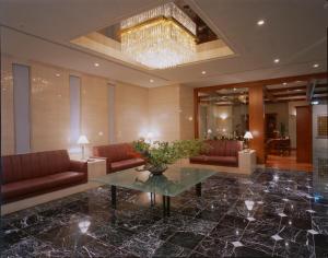 a lobby with couches and a table and a chandelier at Kanazawa Manten Hotel Ekimae in Kanazawa