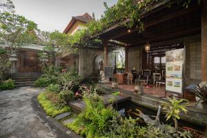 a house with a koi pond in a garden at Om Ham Retreat and Resort in Ubud