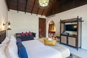 a bedroom with a large bed and a couch at Sriwilai Sukhothai in Sukhothai