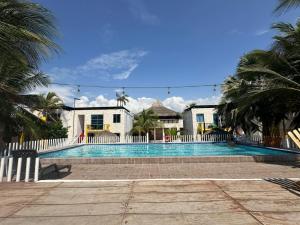 a swimming pool in front of a house with palm trees at Tolu - Caribbean apartment in Santiago