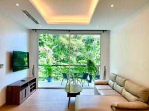 a living room with a couch and a table at Grand Kamala Falls in Kamala Beach