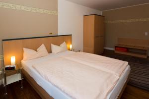 um quarto com uma grande cama branca e 2 almofadas em Apartment Haus em Kleinblittersdorf